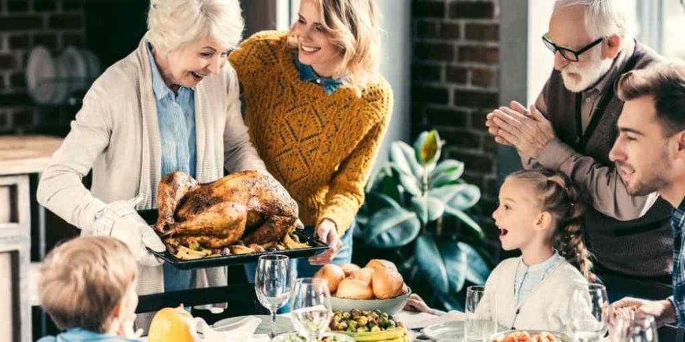 Happy Thanksgiving! A grandmother brings a turkey to a stuffed table.