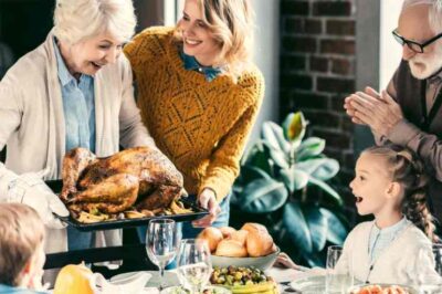 Happy Thanksgiving! A grandmother brings a turkey to a stuffed table.