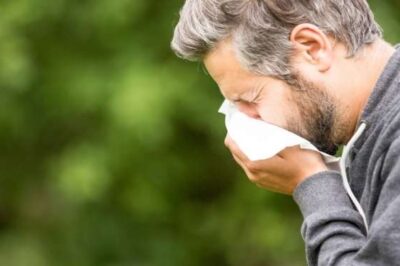 A man sneezes into a handkerchief because he has seasonal allergies.