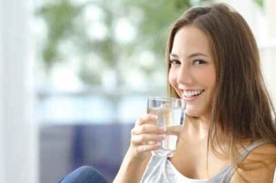 woman drinking water and smiling